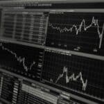 A black and white image of a computer screen showing stock charts.