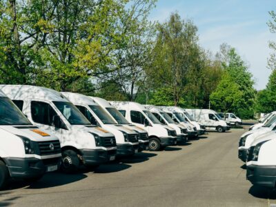 A fleet of white delivery vans parked in a lot, representing fixed assets that can be managed with Sage software