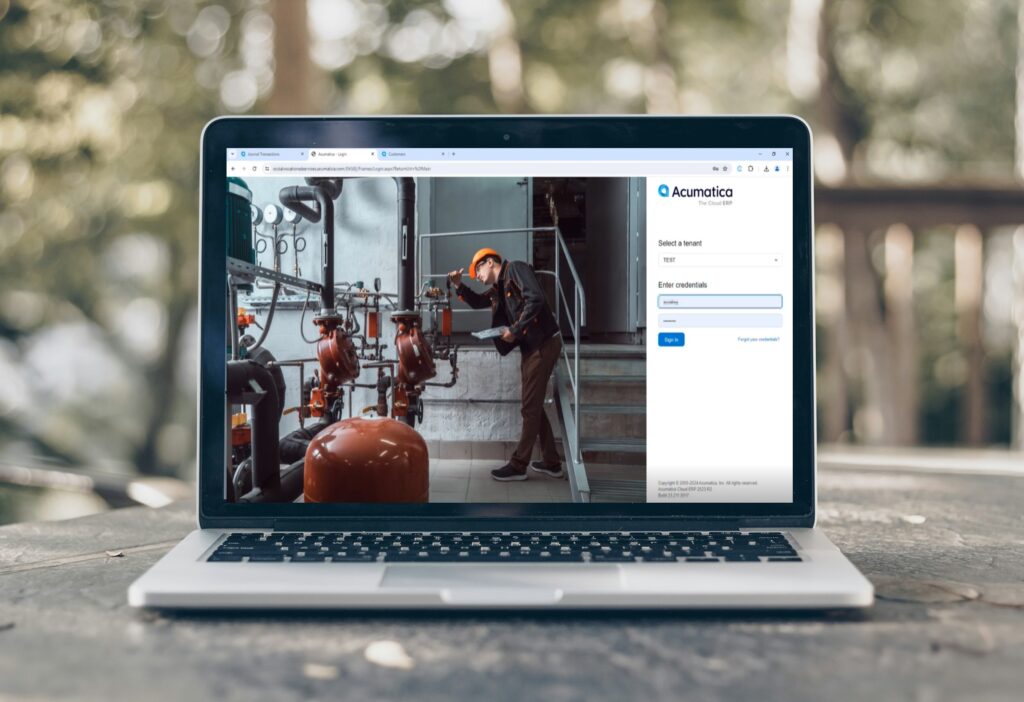 A laptop computer with an Acumatica login page open as part of training with SWK Technologies in a Test tenant environment