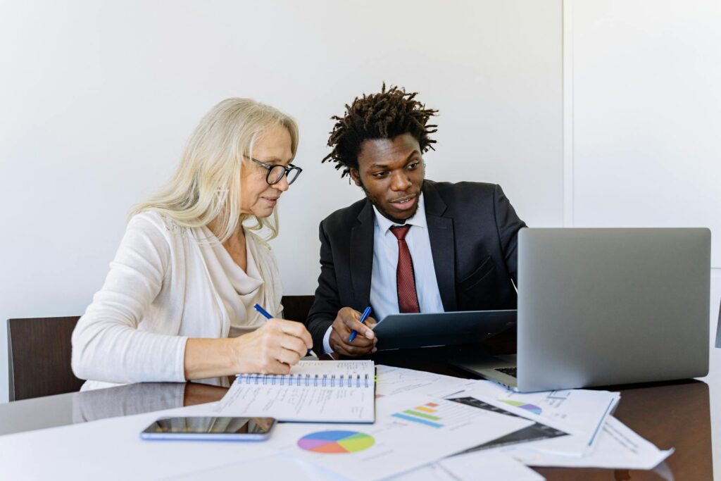 A finance professional and sales team member collaborate over financial reports and data visualizations while implementing integrated business systems, exemplifying the seamless coordination enabled by Sage Intacct's Salesforce integration.