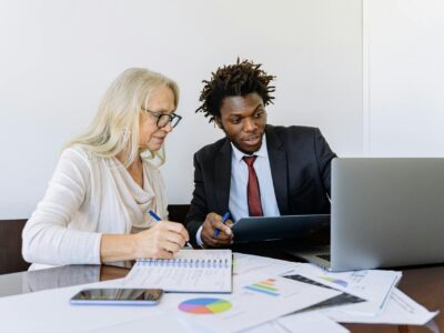 A finance professional and sales team member collaborate over financial reports and data visualizations while implementing integrated business systems, exemplifying the seamless coordination enabled by Sage Intacct's Salesforce integration.